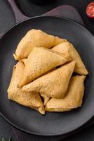 Delicious pancakes triangular shape with meat, salt and spices photo