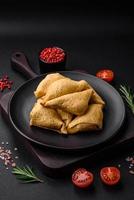 Delicious pancakes triangular shape with meat, salt and spices photo