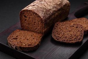 Loaf of fresh crispy brown bread with grains and seeds photo