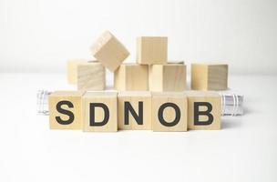 sdnob word made with wooden blocks and white background photo