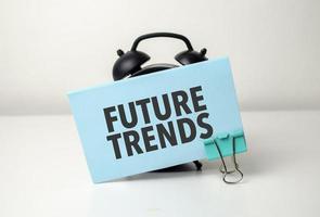 future trends is written in a blue sticker near a black alarm clock photo