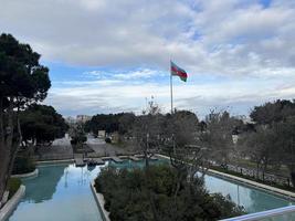 park with pool and azerbaijan flag waving in cloudy weather photo