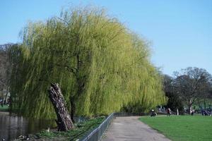 Gorgeous View of Wardown Public Park and People are Enjoying the Beautiful and Bright Sunny Day. They are Spending Day with Their Families and Having Fun. Image Was Captured at Luton on 03-April-2023 photo