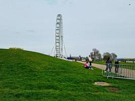 Low Angle View of Willen Lake and Public Park with Ferris Wheel for Fun. People are Enjoying the Start of Summer Season at this Park of Milton Keynes England UK. Footage was Captured on 09-April-202 photo