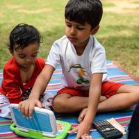 Two happy boys in society park, happy Asian brothers who are smiling happily together. Brothers play outdoors in summer, best friends. Toddler baby boy playing with his happy brother in the garden photo