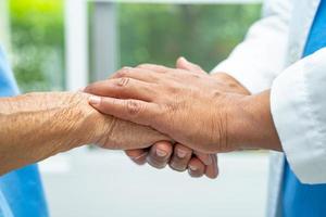 cuidador participación manos asiático mayor mujer paciente con amar, cuidado, animar y empatía a enfermería hospital, sano fuerte médico concepto. foto