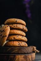 Homemade chocolate chip cookies on rustic wooden coaster and abstract background photo
