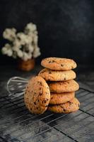 Homemade chocolate chip cookies on black baking cooling tray and abstract background photo