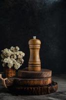 Wooden pepper mill on rustic wooden coaster and abstract background photo
