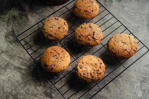 Homemade chocolate chip cookies on black baking cooling tray and abstract background photo