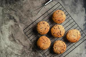 Homemade chocolate chip cookies on black baking cooling tray and abstract background photo