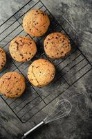 Homemade chocolate chip cookies on black baking cooling tray and abstract background photo