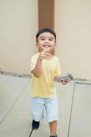 Smiling Asian boy in yellow t-shirt. Blurred background. photo