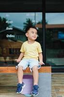 Portrait of an Asian boy wearing a yellow t-shirt. Blurred background. photo