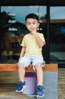 Smiling Asian boy in yellow t-shirt. Blurred background. photo