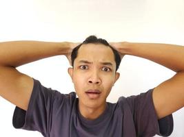 Shocked face of Asian man getting bald and lost hair in isolated white background photo