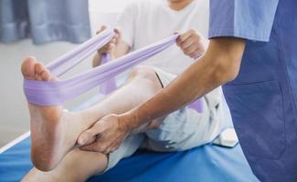 Doctor or Physiotherapist working examining treating injured arm of athlete male patient, stretching and exercise, Doing the Rehabilitation therapy pain in clinic. photo