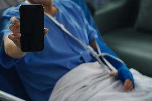 Injured patient showing doctor broken wrist and arm with bandage in hospital office or emergency room. Sprain, stress fracture or repetitive strain injury in hand. Nurse helping customer. First aid. photo