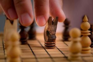 de cerca de empresario manos jugando ajedrez juego. concepto de negocio estrategia y táctica. foto