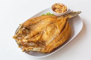 Deep fried sea bass or Fried snapper with fish sauce and spicy mango salad. photo