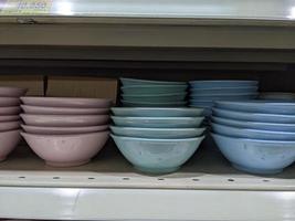 Lot of bowl and plate on the rack mini market. The photo is suitable to use for promotion picture and discount background.