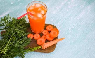 carrot juice on wooden table background, fresh and sweet carrot slices for cooking food fruits and vegetables for health concept, fresh carrots juice on glass with ice on summer photo