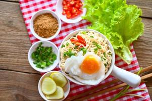 noodles bowl with boiled egg minced pork vegetable spring onion lemon lime lettuce celery and chili on table food, noodle soup instant noodles cooking tasty eating with plate photo