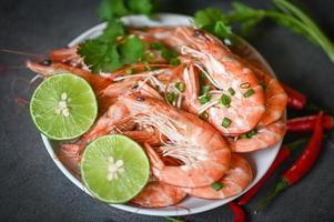 shrimp on white plate background dining table food, Fresh shrimps prawns seafood lemon lime with herbs and spice photo