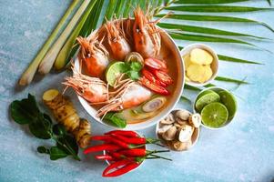 Thai Food Tom Yum Kung, Hot and sour spicy shrimps prawns soup  curry lemon lime galangal red chili straw mushroom on table food, Shrimp soup on seafood soup bowl with thai herb and spices photo