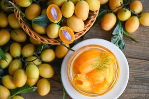 Sweet dessert marian plum fruit  on bowl for food and wooden background, tropical fruit Name in Thailand sweet Yellow Marian Plum Maprang Plango or Mayong chid photo