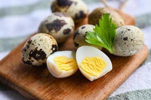 boiled eggs food, quail eggs on wooden plate, breakfast eggs with fresh quail eggs and vegetable coriander on food table background photo