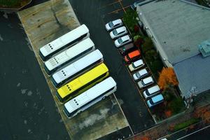 parte superior ver de coche estacionamiento lote con turista autobuses en el otoño. foto