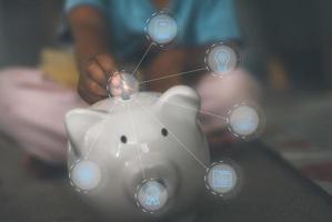 saving plan for child education expenses study scholarship concept. child hand is inserting coin in to piggy bank with learning icons, child bursary university concept photo