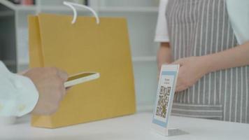 klant gebruik smartphones naar scannen qr codes naar betalen in de winkel met digitaal betalingen zonder contant geld. scannen krijgen kortingen. e portemonnee, technologie, online betaling, bank app, slim stad, geld overdracht. video