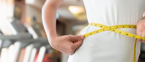 dieta y dieta. cinta métrica de uso de cuerpo femenino delgado de belleza. mujer con ropa de ejercicio logra el objetivo de pérdida de peso para una vida saludable, loca por la delgadez, cintura delgada, nutricionista. foto