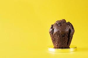Chocolate muffin on a yellow background. Cake. Chocolate sweets. Bakery. photo