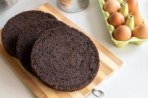 chocolate marrón galleta redondo pastel capas mentira en el cocina mesa, pollo huevos en el bandeja foto