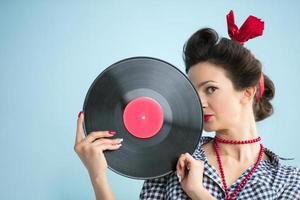 retro mujer en cincuenta estilo sostiene un musical registro. foto