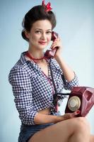 Woman in the style of the fifties. Retro woman holds a phone. photo