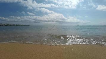 lento movimento do ampla onda quebra em a de praia com espuma e surfar video