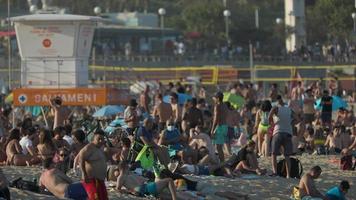 Menschenmassen von Menschen auf das Strände von Barcelona im Sommer- video