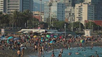 Menschenmassen von Menschen auf das Strände von Barcelona im Sommer- video