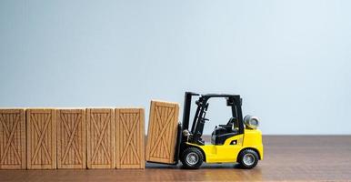 un máquina elevadora hace un cerca pared fuera de de madera cajas masa producción. entrega de parcelas y pedidos. comercio tráfico. transporte y transferir. logística. entrega de de gran tamaño carga. foto