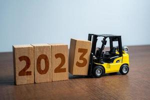 Forklift truck makes 2023 year from blocks. Trends and forecasts for business in 2023. New plans for next year. Summing up, analytics and forecasting. Analysis companys economic performance. photo