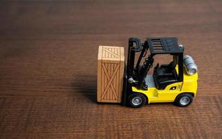 A forklift truck transports a wooden crate box. Trading transportation services. Import export. Warehousing. Tracking deliveries. Shipping. Packing and transportation logistics. photo