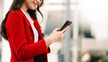 Businesswoman using mobile phone, tablet.Closeup on office background photo