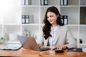 businesswoman or accountant hand typing laptop working to calculate on desk about cost at home office. photo