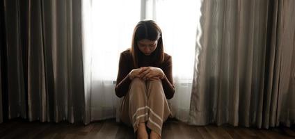 woman sit Depression Standing by window and anxiety Copy space. photo