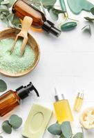 Eucalyptus, towel, massage salt, aroma oil,  spa objects on white tile background. photo