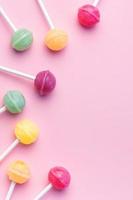 piruletas dulces sobre fondo rosa foto
